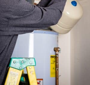 Professional plumber doing water heater tune up.