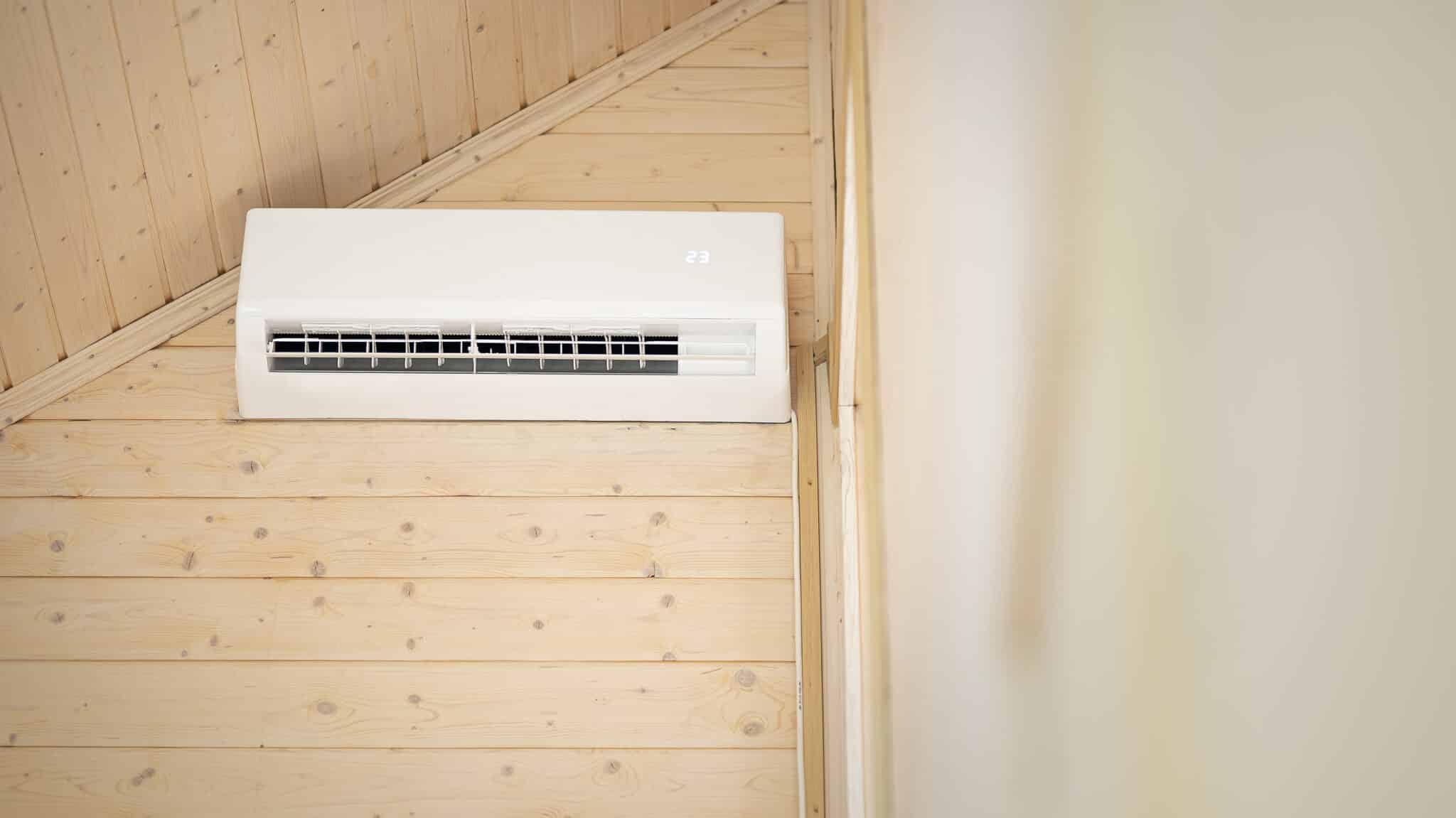 Ductless Mini Split Sizing and Placement in Oak Ridge 2 White air conditioner on the wall of a wooden house, ductless mini split sizing and placement in Oak Ridge.